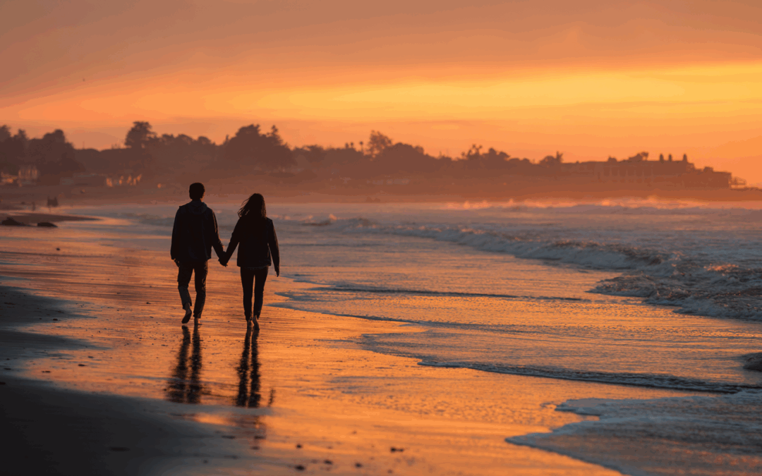 man and woman walking down the beach on a date in santa cruz