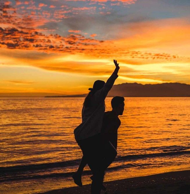 man-holding-woman-back-evening-sea-shore